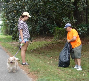 Sarah and Michael Defeley pick up trash under Misha's watchful eye.